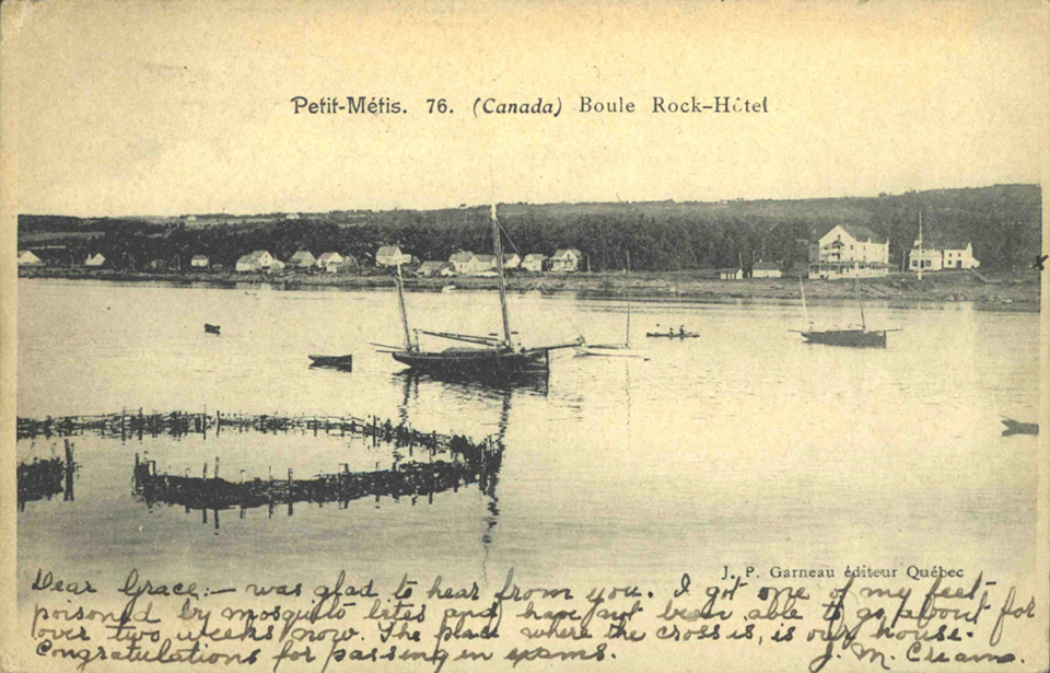 Postcard from Metis showing the village from the river. In the foreground, a fascine fishing installation. A number of small pleasure craft can be seen on the water.