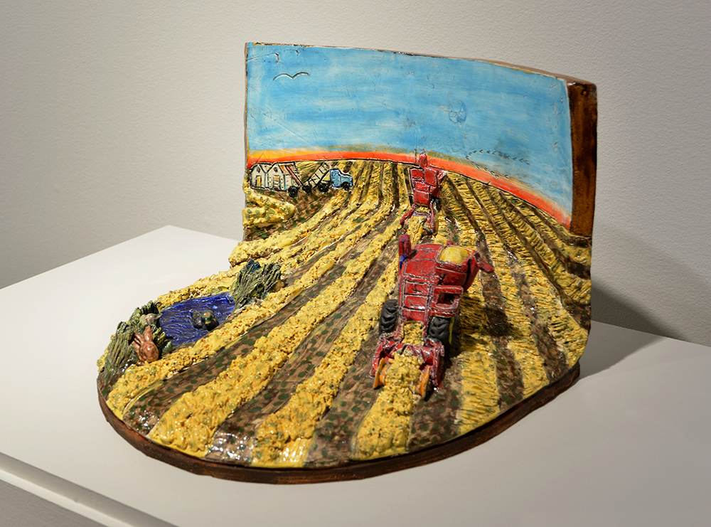 Ceramic diorama sculpture of a field with machines in it