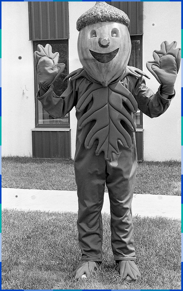 A black and white photograph of Glandinot. He has an acorn-shaped head and a happy look on his face. His hands and body are made of oak leaves, as are his shoes.