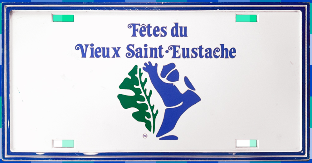 A Fêtes du Vieux Saint-Eustache licence plate. The name of the event is written in blue at the top center of the plate. Below that is a blue acorn-headed figure with a green oak leaf on his back. The plate has four holes.