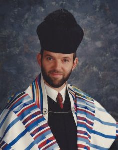 A headshot of Cantor Sidney Dworkin, wearing formal cantorial robes and a prayer shawl.