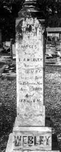 Black and white photograph of a rectangular marble cemetery headstone with carved inscription reading “In memory of Moses son of T & A Webley. Native son of Northfield B.C. who met his death in Extension Mine June 7 1909 Aged 14 years 6 months. Gone but not forgotten.”
