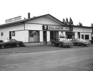 Black and white photograph: facade of a commercial building 