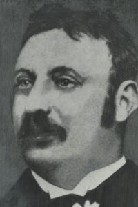 A late 19th century black-and-white detailed sketch of a man with a short moustache wearing a suit, John E. Moss.