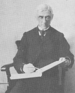 A seated man holding an account book in which he writes