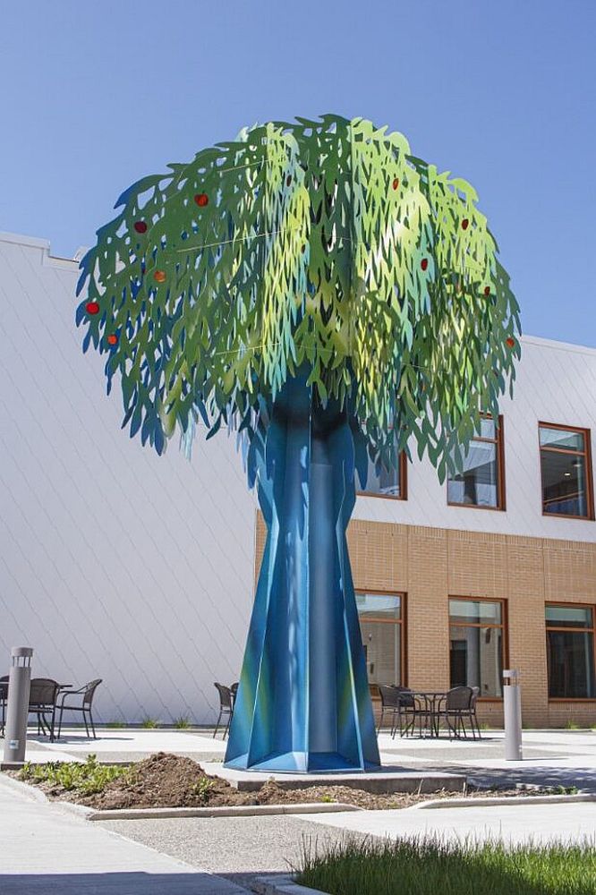 Sculpture: a giant apple tree in front of a building