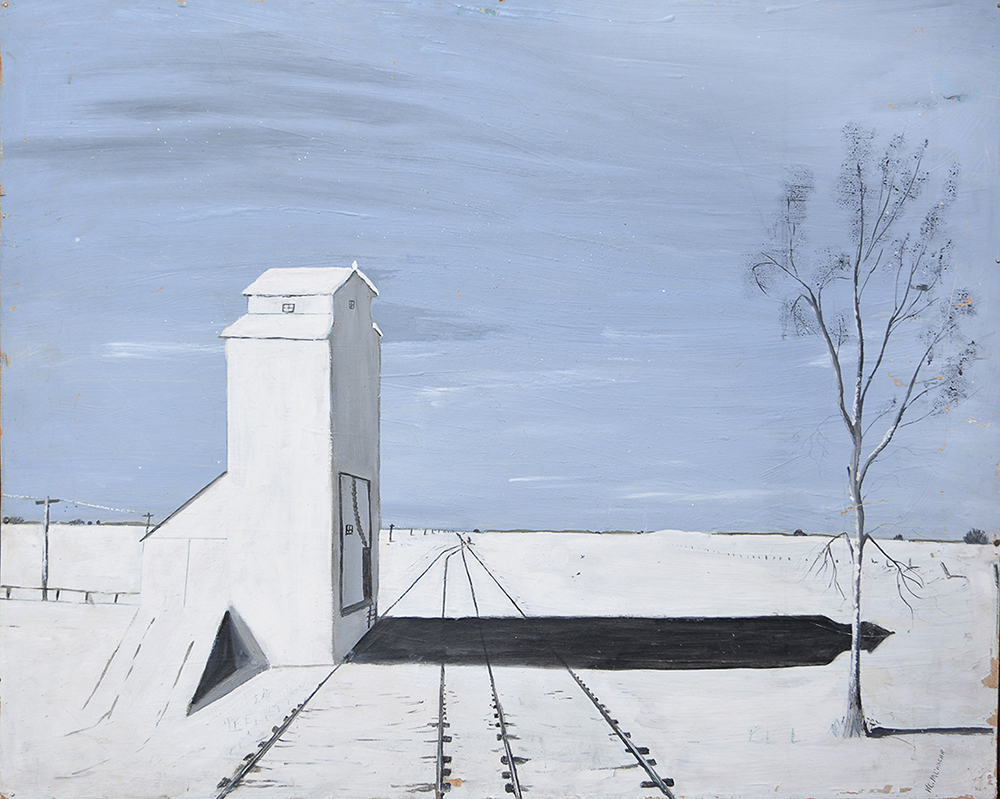 A grain elevator casting a shadow on snowy ground