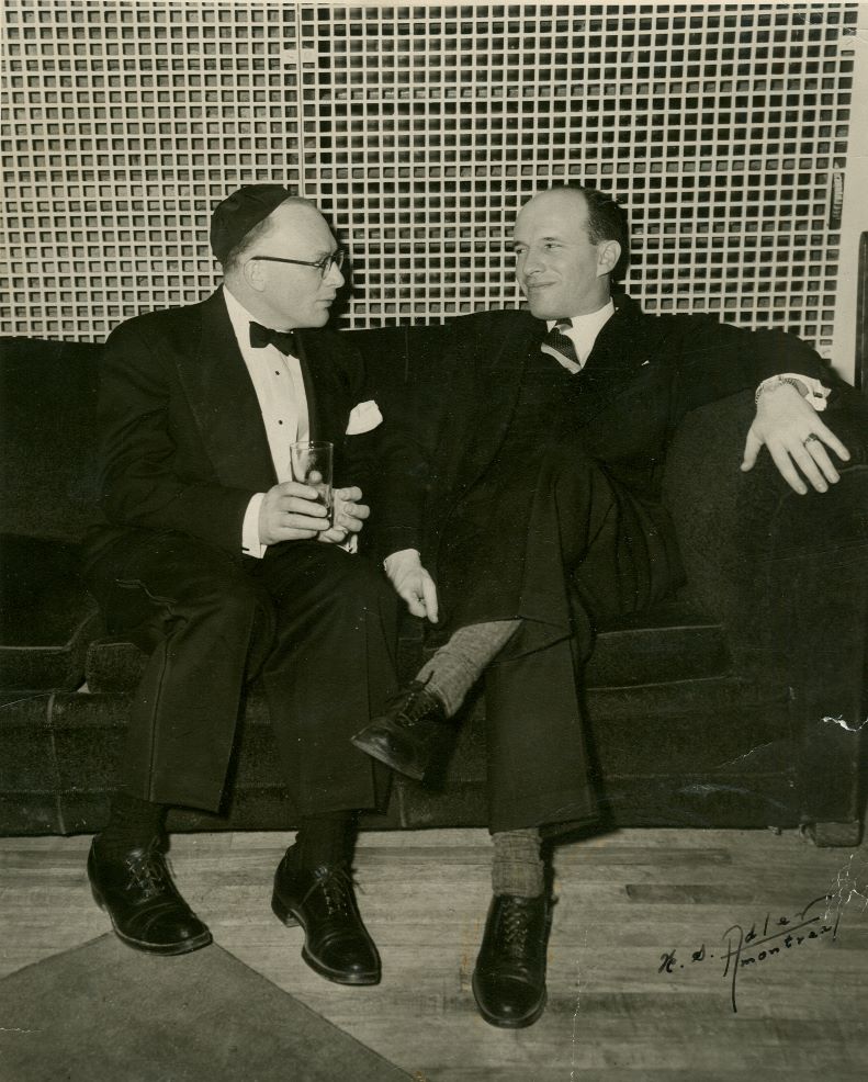 Black-and-white photograph of two men sitting on a couch.