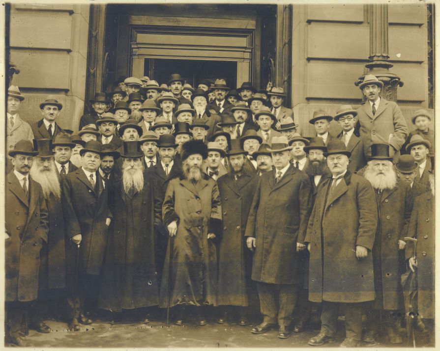 Rav Kook, Chief Rabbi of Palestine, stands with large group of Men outside of City Hall
