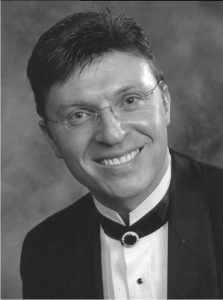A black-and-white headshot of Stephen Glass, wearing a formal suit.