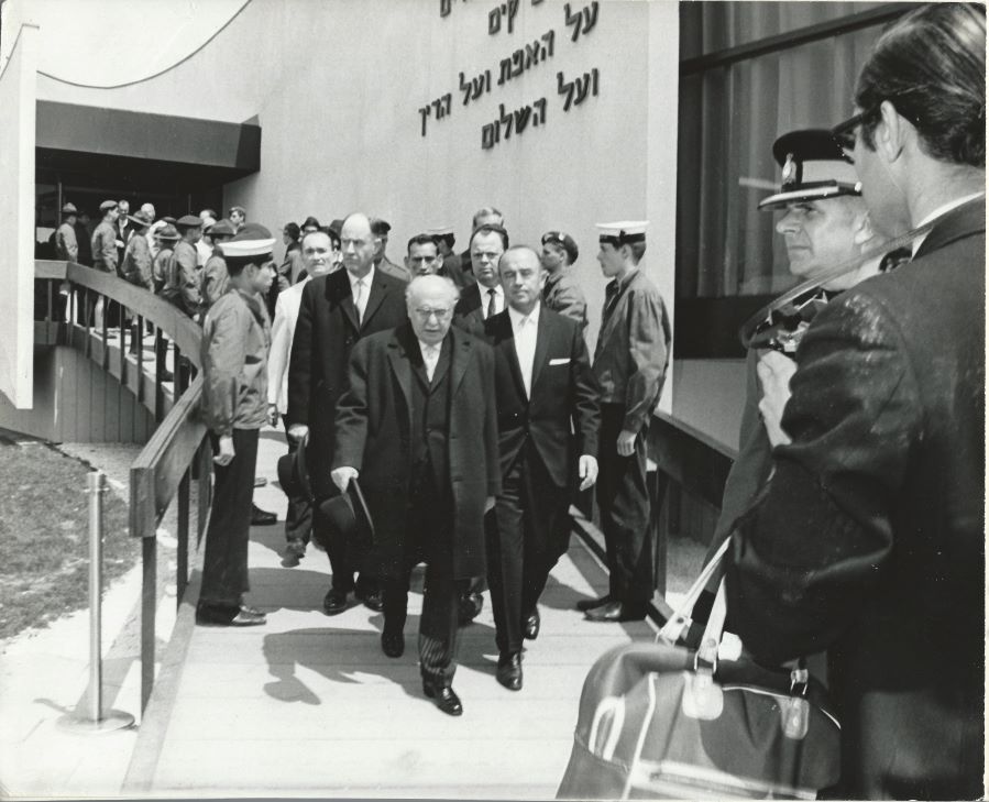 A black-and-white photograph of a group of me walking down a ramp, exiting the Pavilion of Judaism at Expo 67.